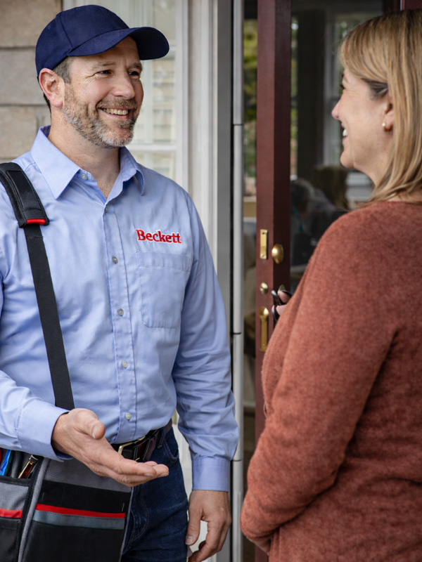 Beckett oil burner repair technician servicing unit on Long Island